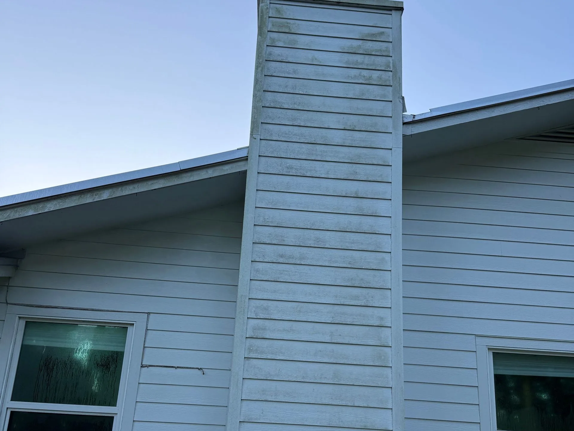 Before: chimney and siding streaked grey with mildew