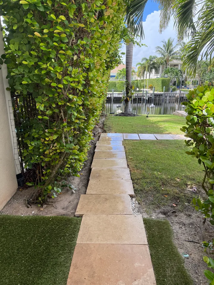 Clean stone stepping-stone path through a side yard leading toward the water