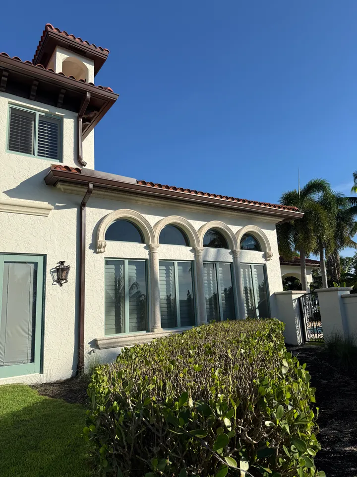 Row of clean arched windows on a Mediterranean-style home under a barrel-tile roof