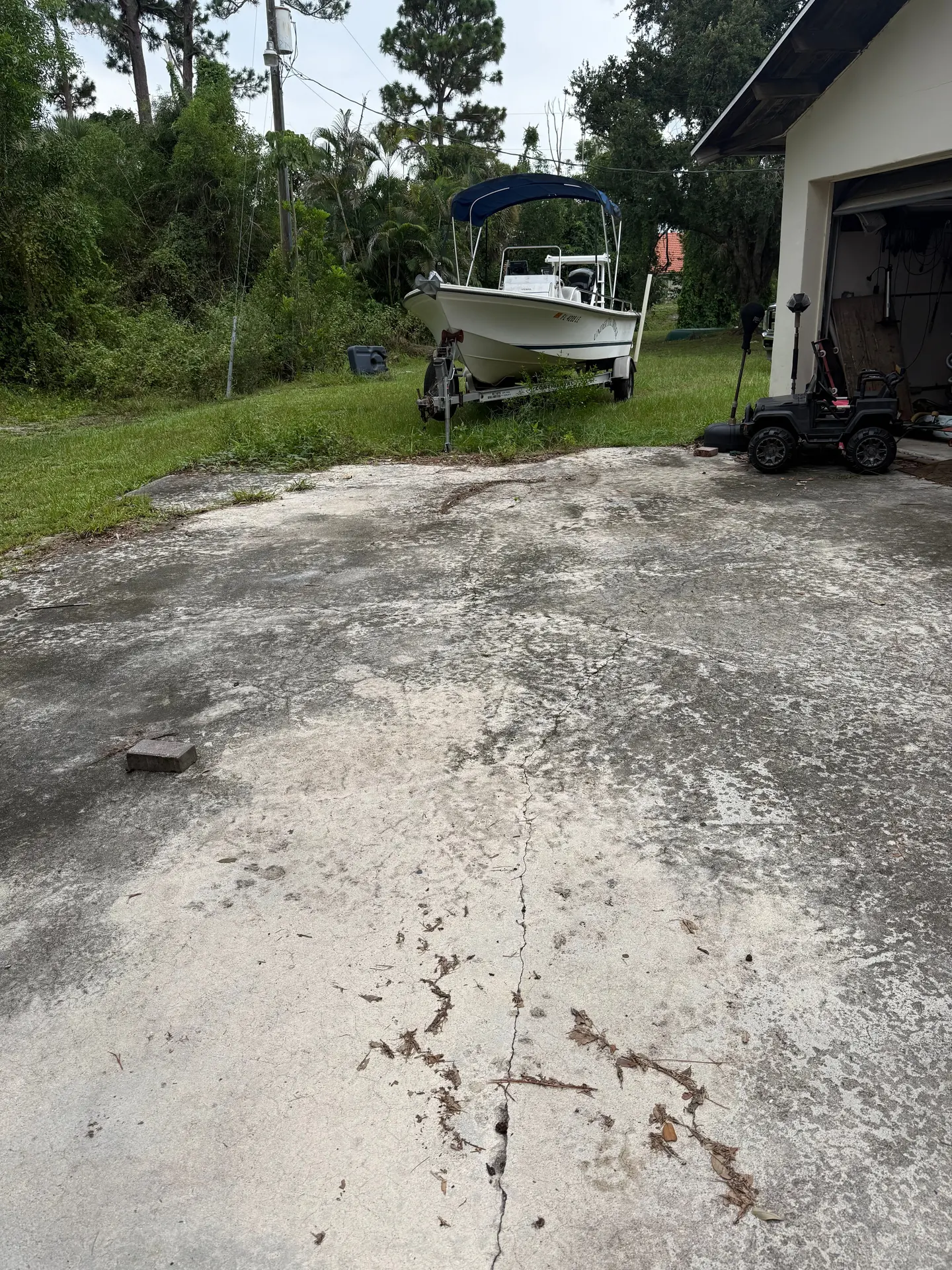 Before: cracked, blackened concrete driveway