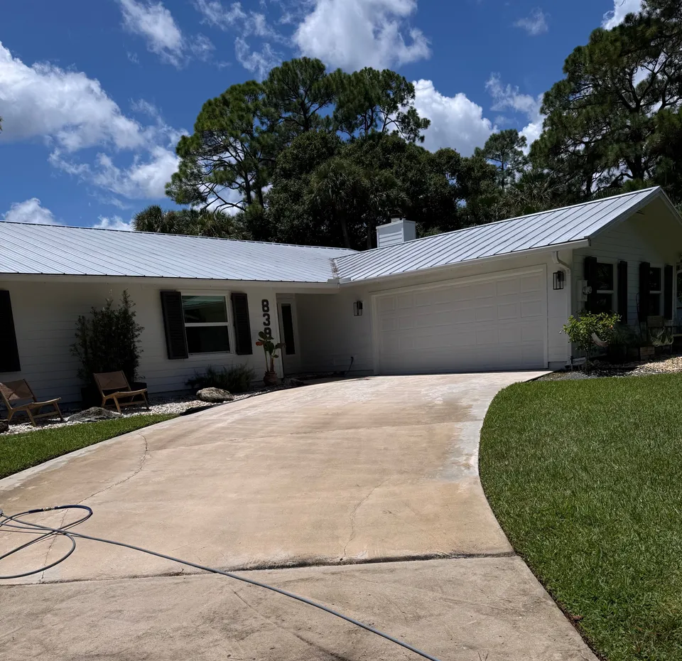 Driveway restored to a clean, even finish in front of a white ranch home