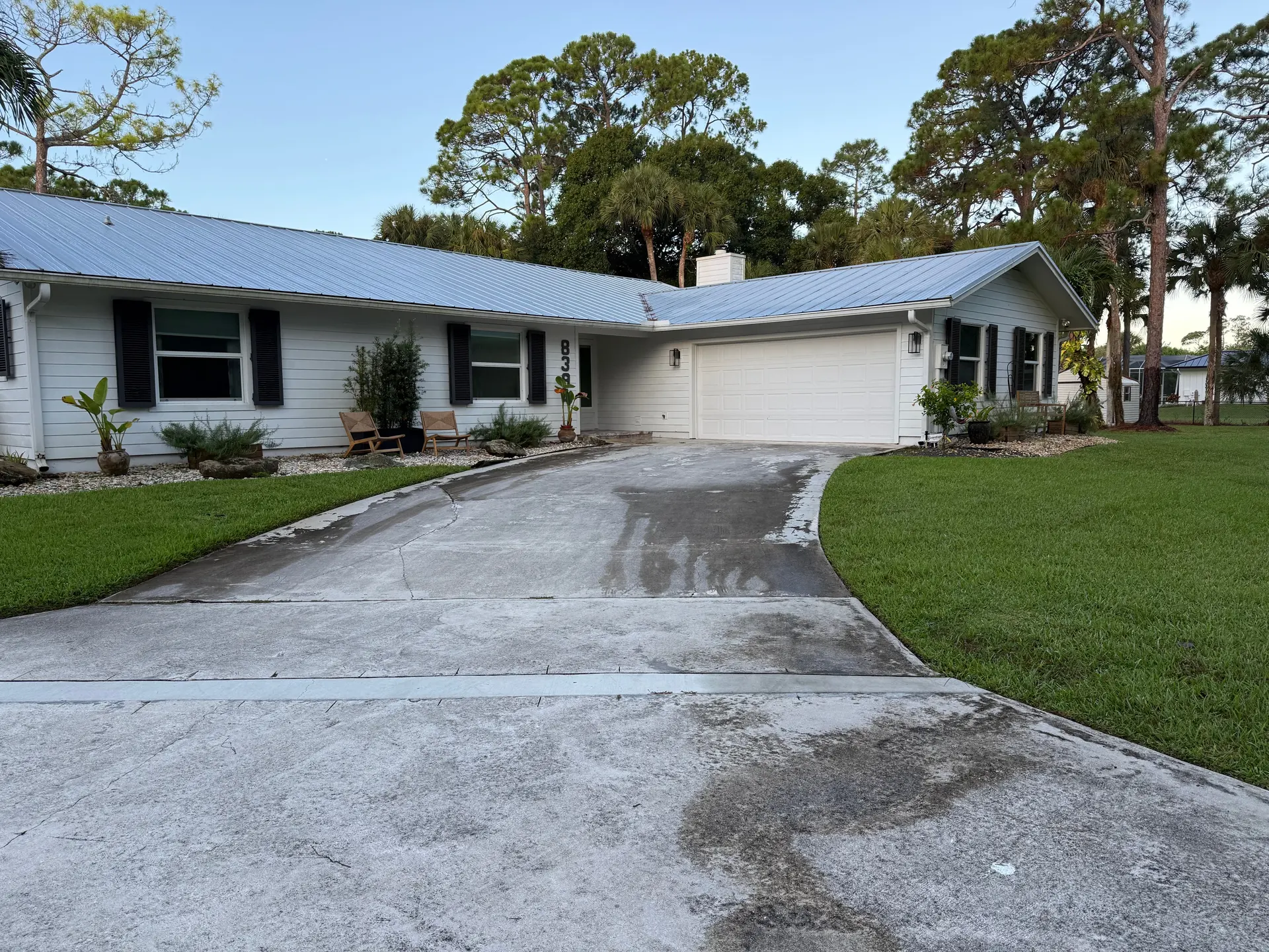 Before: gray, stained driveway in front of a ranch home