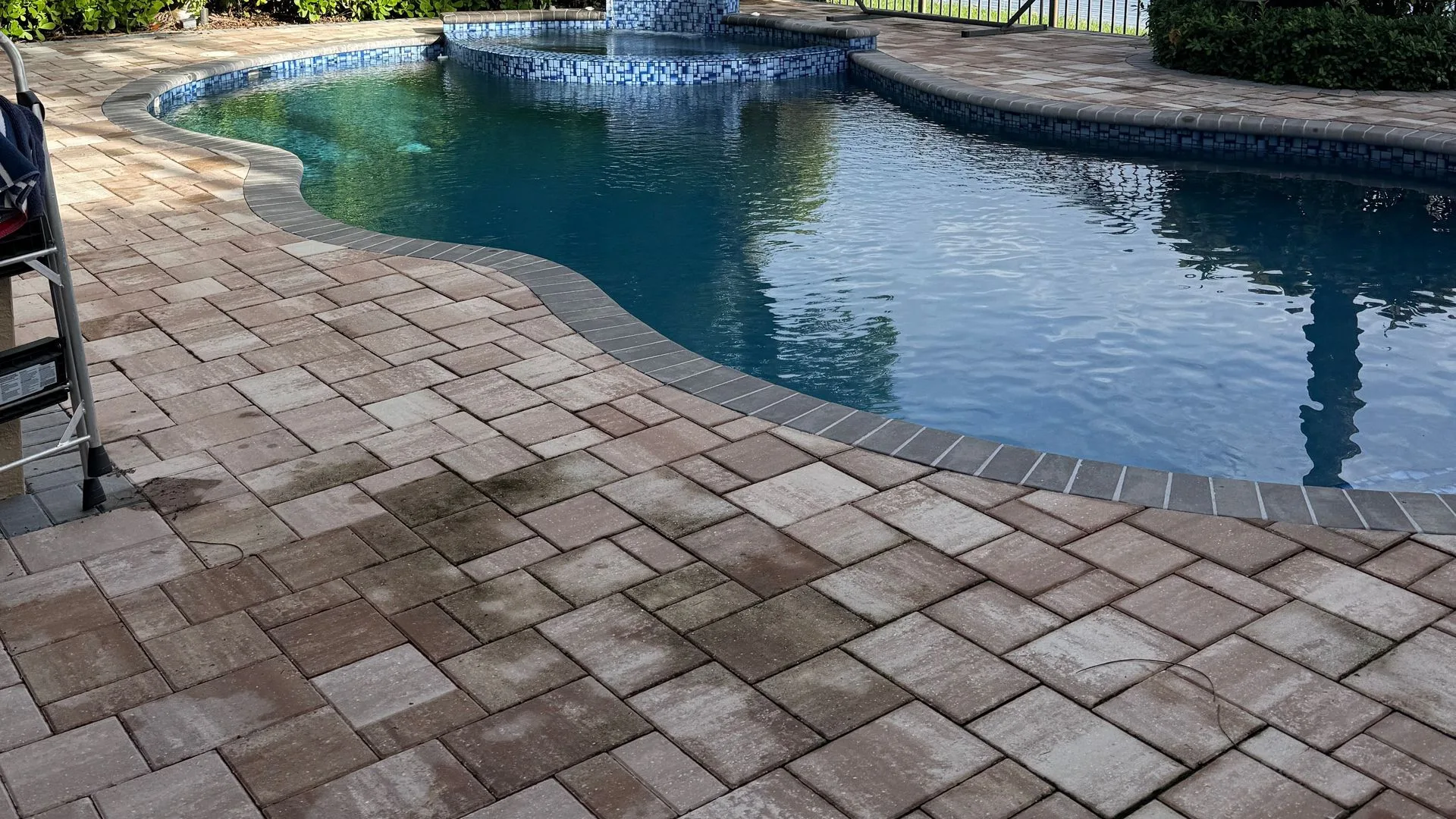 Before: paver pool patio darkened with algae and grime